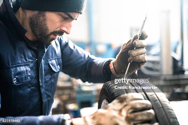 tire repairer checking the tire integrity - thick stock pictures, royalty-free photos & images