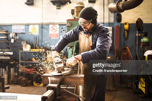 handarbeiter in einer werkstatt mit dem schleifer - blacksmith sparks stock-fotos und bilder