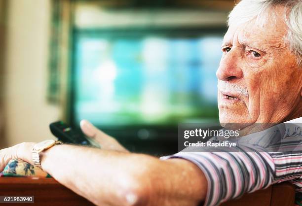 grumpy 90-yer-old man disturbed while watching tv - grumpy old man stock pictures, royalty-free photos & images