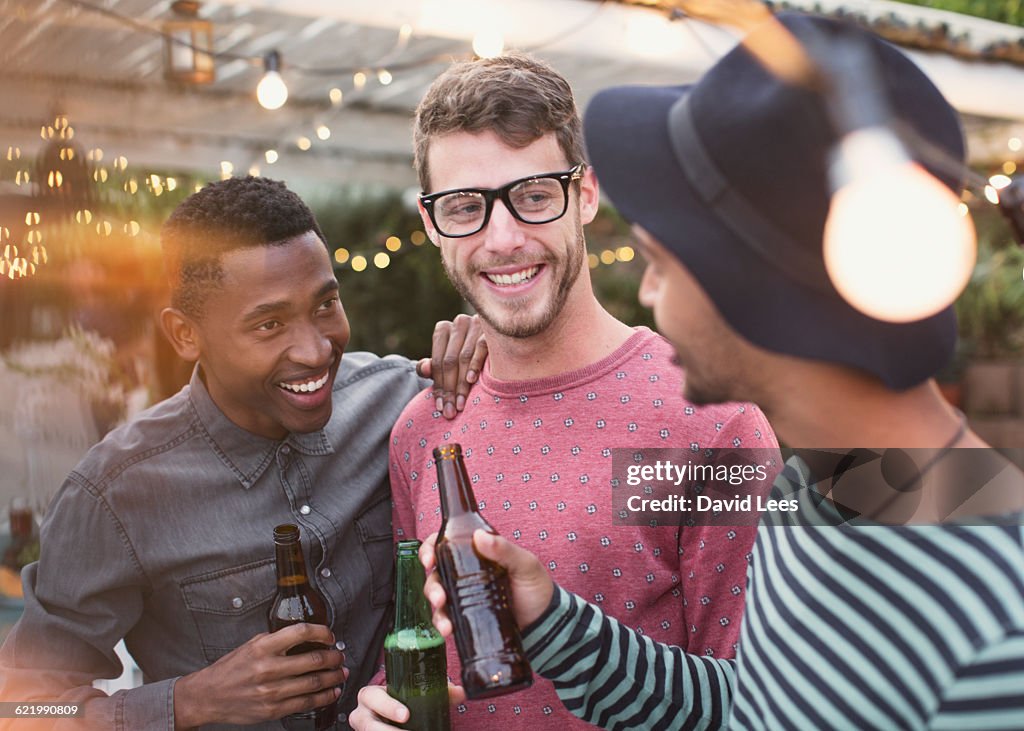 Friends drinking and laughing at poolside party