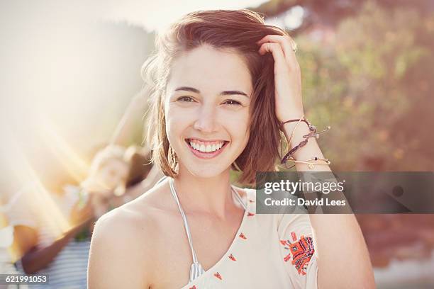 smiling woman at poolside party - hand in den haaren stock-fotos und bilder