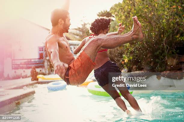 friends jumping into swimming pool at pool party - swimming pool jump stock pictures, royalty-free photos & images