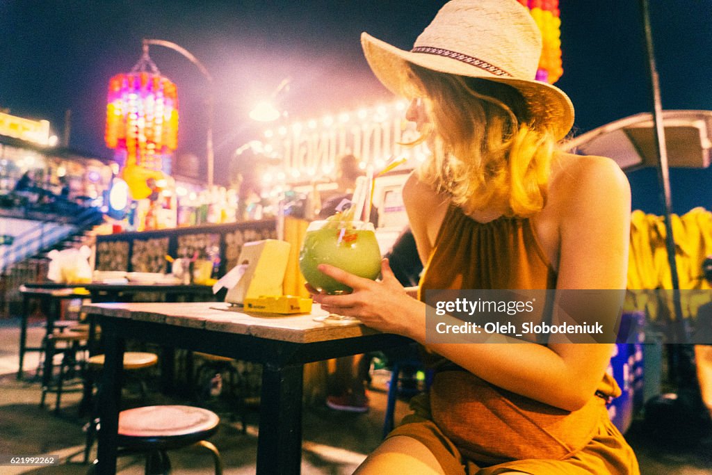 Woman drinking cocktail at night