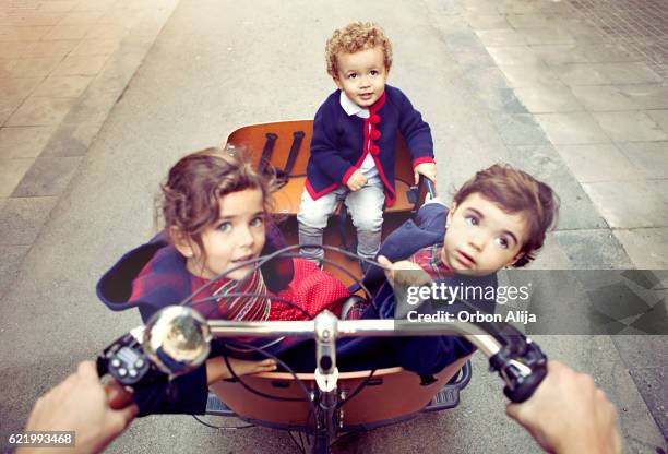 padre montando bicicleta de carga - family with three children fotografías e imágenes de stock