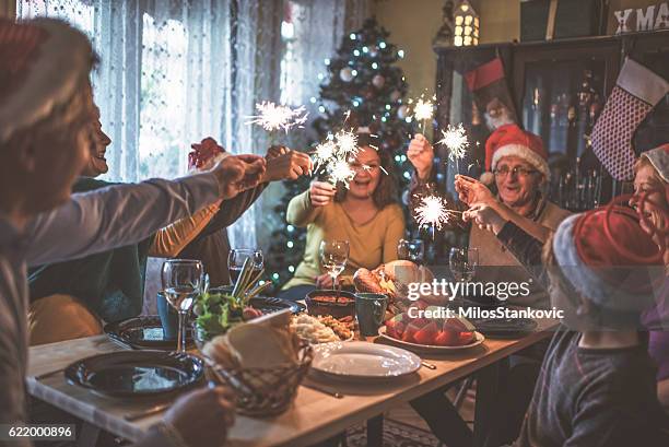 family celebrating christmas for many years together - christmas living room stock pictures, royalty-free photos & images