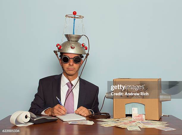 businessman makes money with helmet and money machine - market intelligence imagens e fotografias de stock