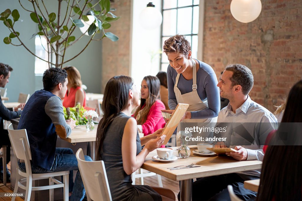 Friendly waitress serving couple at a restaurant