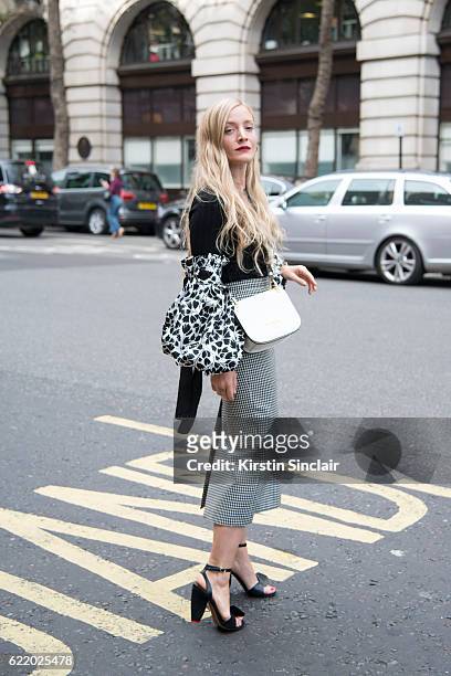 Fashion Stylist Kate Foley Osterweis wears a Miu Miu skirt, Prada bag, Valentino shoes, Simon Miller sweater, Marni sleeves day 4 of London Womens...