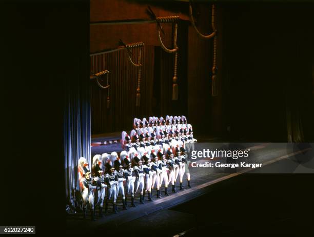 The Rockettes dance a precise military number on the Radio City Music Hall stage, Rockerfeller Center, New York, NY, 1942.