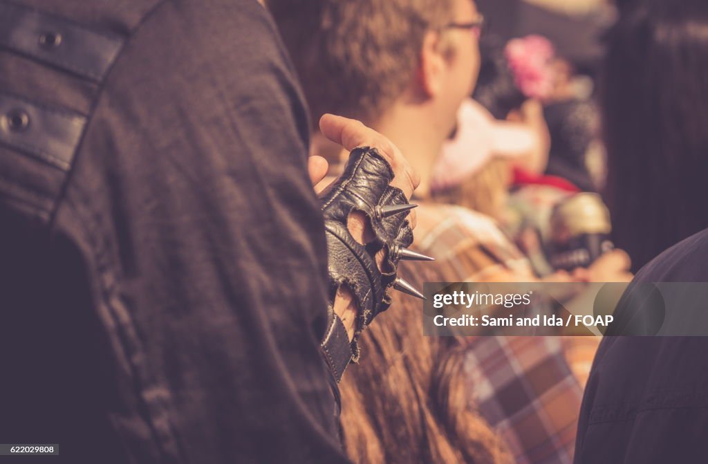 A person wearing leather spiked glove in hand