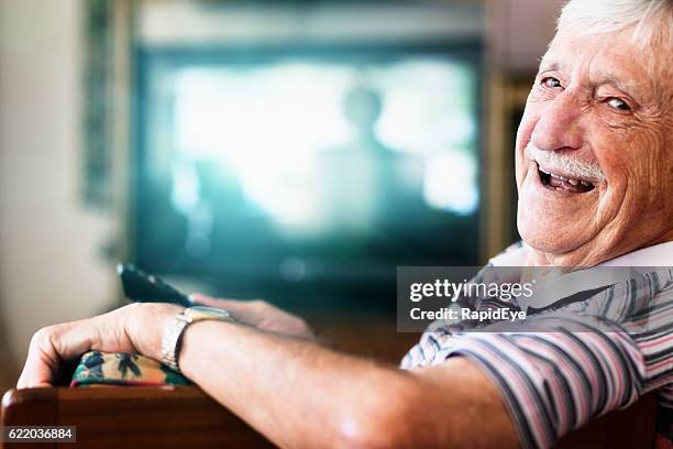 happy 90-year-old man in charge of the tv remote control - old television stock pictures, royalty-free photos & images
