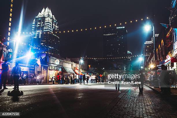 downtown austin at night on sixth ave - austin texas stock pictures, royalty-free photos & images