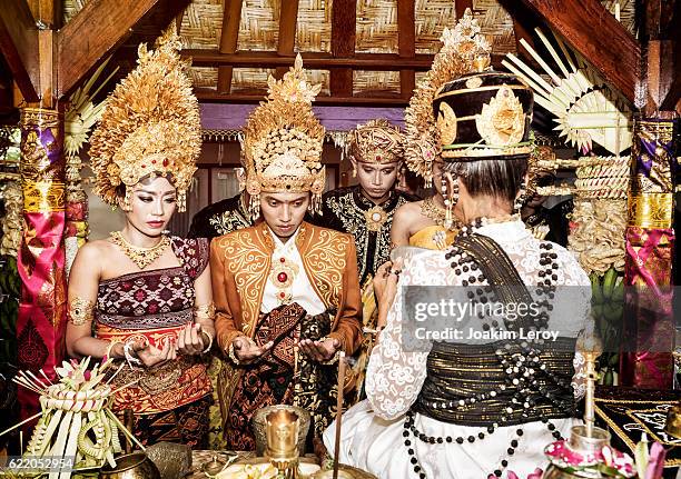 balinese couple getting blessed for their wedding in bali - balinese culture stock pictures, royalty-free photos & images