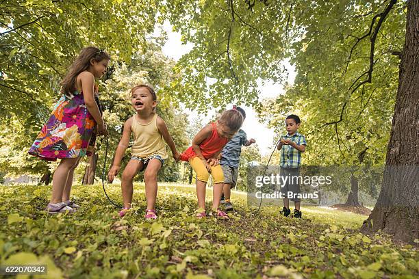 below view of carefree children skipping the jumping rope. - jump rope stock pictures, royalty-free photos & images