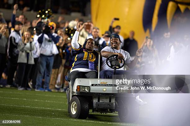 Former California running back Marshawn Lynch with his mother Delisa driving a golf cart on field and leading California players onto field before...