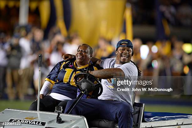 Former California running back Marshawn Lynch with his mother Delisa driving a golf cart on field and leading California players onto field before...