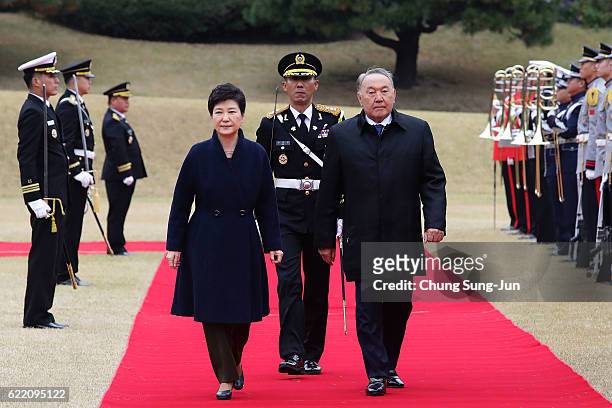South Korean President Park Geun-Hye and Kazakhstan President Nursultan Nazarbayev walk towards a guard of honour during a welcoming ceremony at the...