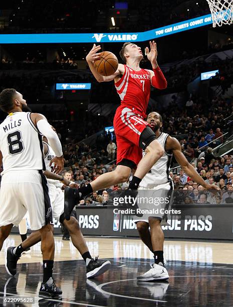 Sam Dekker of the Houston Rockets loses control of the ball as he drives pas San Antonio Spurs defenders at AT&T Center on November 9, 2016 in San...
