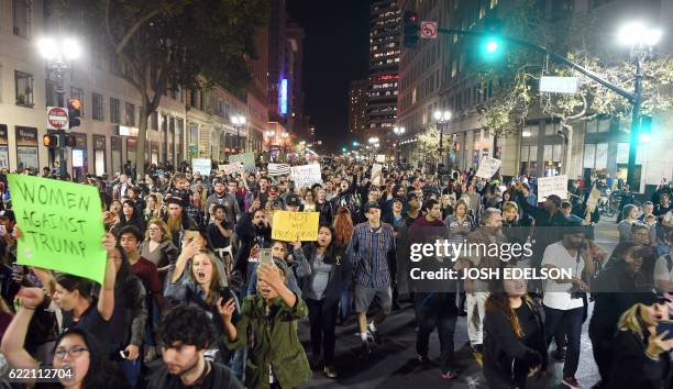 People march and shout during an anti-Trump protest in Oakland, California on November 9, 2016. Thousands of protesters rallied across the United...