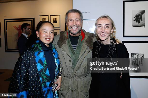 Jean-Paul Goude standing between his wife Karen Park Goude and Carla Sozzani attend the Carla Sozzani : Photo Exhibition at Azzedine Alaia Gallery on...