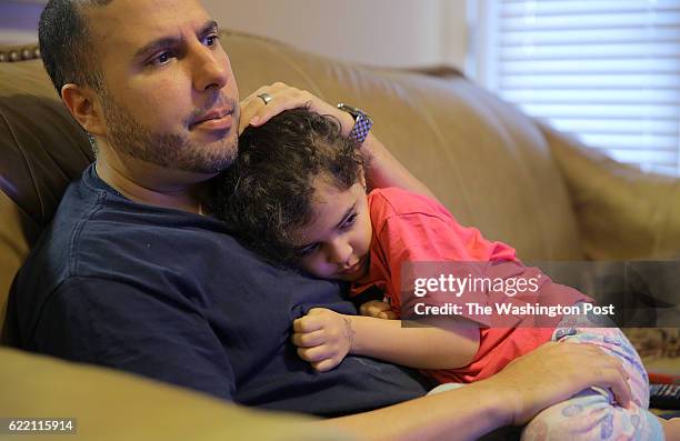 Shadi Sadi, holding 5-year-old daughter Saja Sadi while watching the news at home in Raleigh, NC, Wednesday morning, November 9 says he's worried...