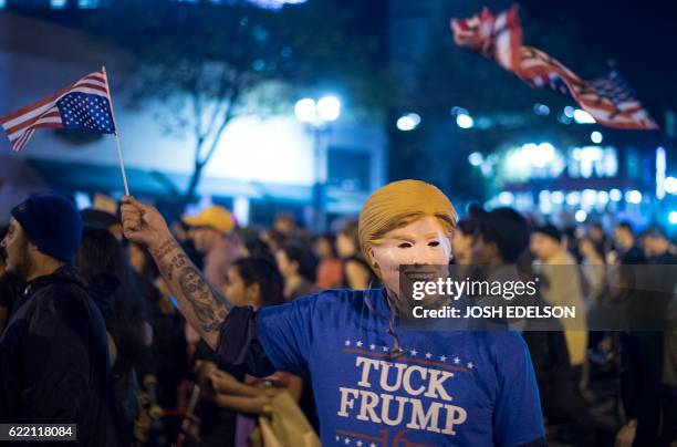 Protester wears a Hillary Clinton mask during an anti-Trump protest in Oakland, California on November 9, 2016. Thousands of protesters rallied...