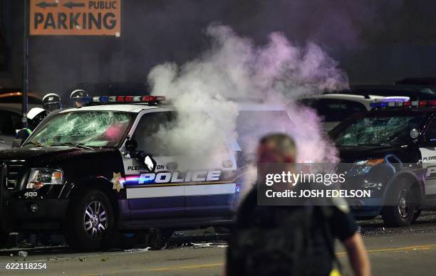 Police vehicle is seen on fire during an anti-Trump protest in Oakland, California on November 9, 2016. Thousands of protesters rallied across the...