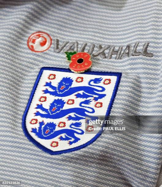 England's midfielder Jordan Henderson wears a poppy on his shirt in honour of Remembrance Day, as he speaks during a press conference at St George's...