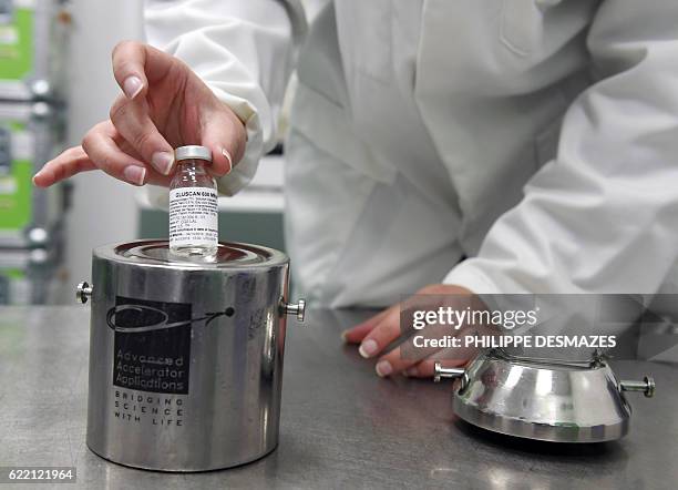 Pharmacist puts a dose of Gluscan, a sugar associated with a radioactive fluorine, inside a box protected by lead in a laboratory of the...