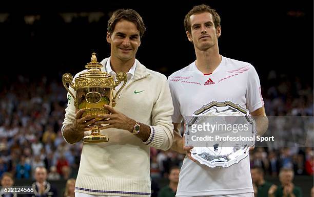 Winner Roger Federer of Switzerland and runner up Andy Murray of Great Britain hold their trophies after their Gentlemen's Singles final match on day...