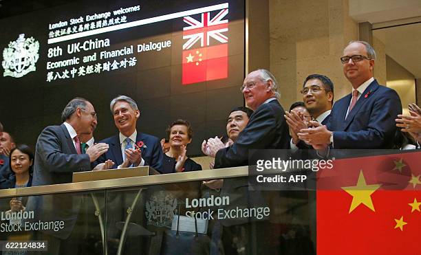 British Chancellor of the Exchequer Philip Hammond , Bank of China chairman Tian Guoli , and London Stock Exchange Group CEO Xavier Rolet react after...