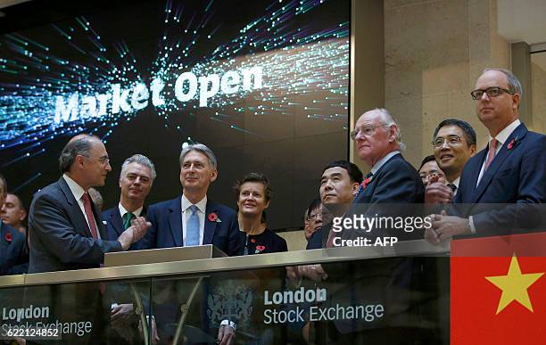 British Chancellor of the Exchequer Philip Hammond , Bank of China chairman Tian Guoli , and London Stock Exchange Group CEO Xavier Rolet open the...