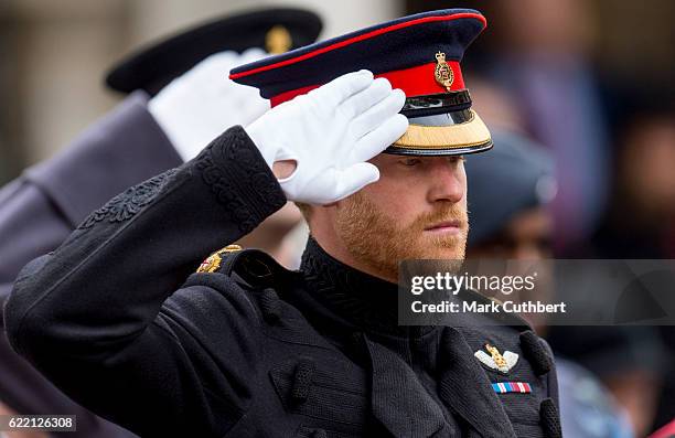 Prince Harry salutes during a visit to the Fields of Remembrance at Westminster Abbey on November 10, 2016 in London, England.