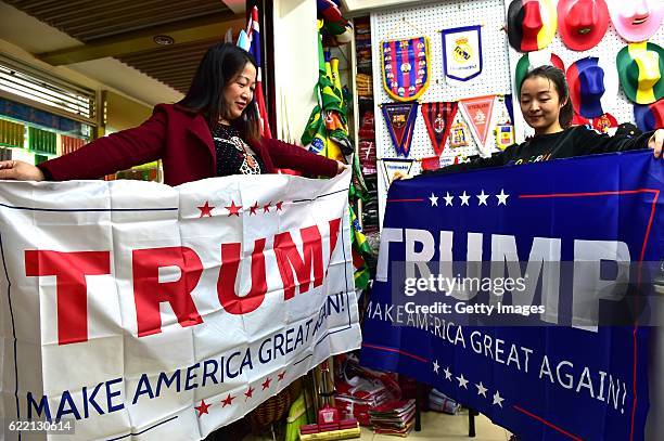 Two women running business of banners pose with support banners for Republican presidential candidate Donald Trump at Yiwu International Trade Centre...