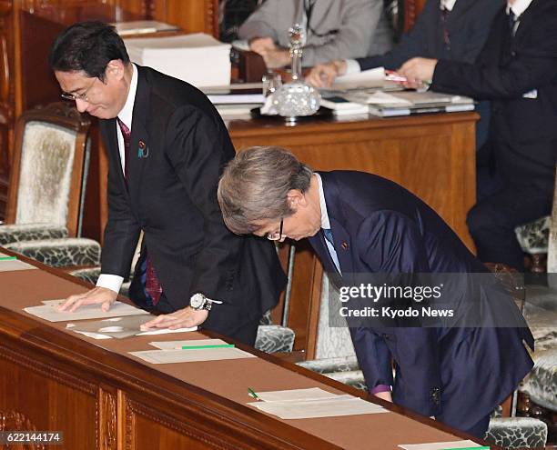 Fiscal Policy Minister Nobuteru Ishihara and Foreign Minister Fumio Kishida bow to the chamber of the House of Representatives, which voted to ratify...