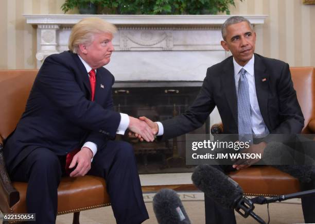 President Barack Obama and President-elect Donald Trump shake hands during a transition planning meeting in the Oval Office at the White House on...