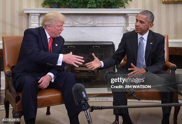 President Barack Obama shakes hands as he meets with Republican President-elect Donald Trump on transition planning in the Oval Office at the White...