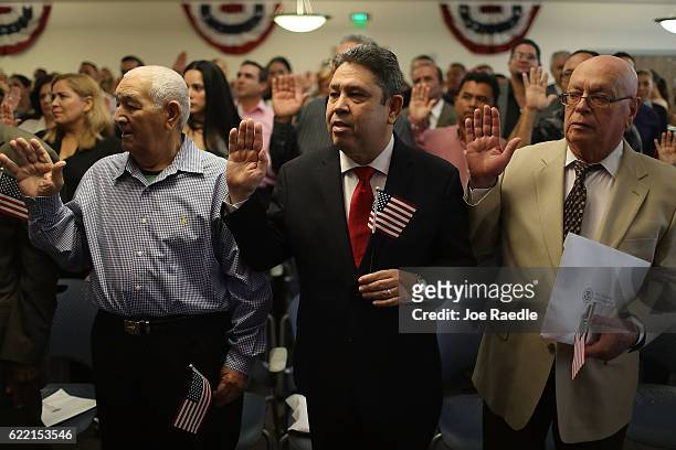 Emilio Rodriguez , originally from the Dominican Republic, holds an American flag as he becomes an American citizen during a ceremony at the U.S....