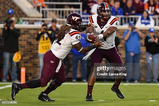 Jerod Evans hands off to Marshawn Williams of the Virginia Tech Hokies during their game against the Duke Blue Devils at Wallace Wade Stadium on...