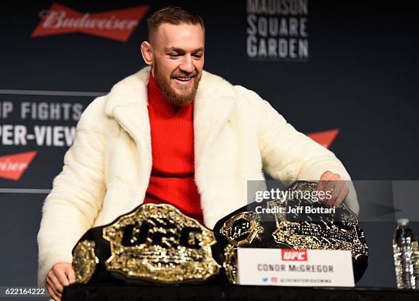 Featherweight champion Conor McGregor of Ireland takes the belt of lightweight champion Eddie Alvarez during the UFC 205 press conference inside The...