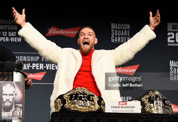 Featherweight champion Conor McGregor of Ireland takes the belt of lightweight champion Eddie Alvarez during the UFC 205 press conference inside The...