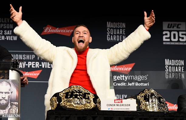 Featherweight champion Conor McGregor of Ireland takes the belt of lightweight champion Eddie Alvarez during the UFC 205 press conference inside The...