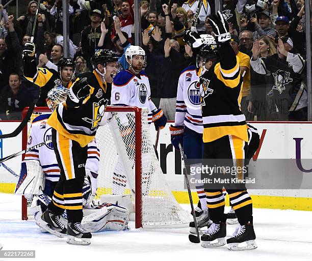 Conor Sheary of the Pittsburgh Penguins celebrates with teammates after scoring the game winning goal against the Edmonton Oilers at PPG PAINTS Arena...