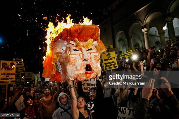 Anti-Trump protesters burn an effigy of the president-elect, Donald Trump, outside City Hall in Los Angeles, Calif., on Nov. 9, 2016.