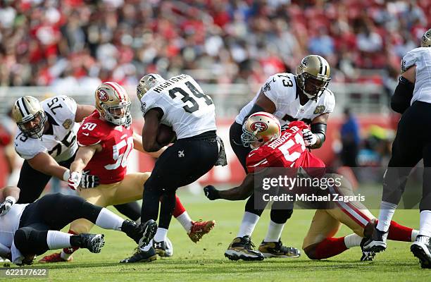 Nick Bellore and Gerald Hodges of the San Francisco 49ers tackle Tim Hightower of the New Orleans Saints during the game at Levi Stadium on November...