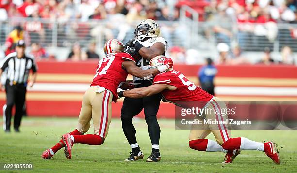 Keith Reaser and Michael Wilhoite of the San Francisco 49ers tackle Mark Ingram of the New Orleans Saints during the game at Levi Stadium on November...