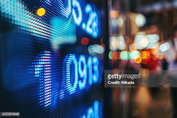 display stock market numbers with defocused street lights background - digital display sign stock pictures, royalty-free photos & images