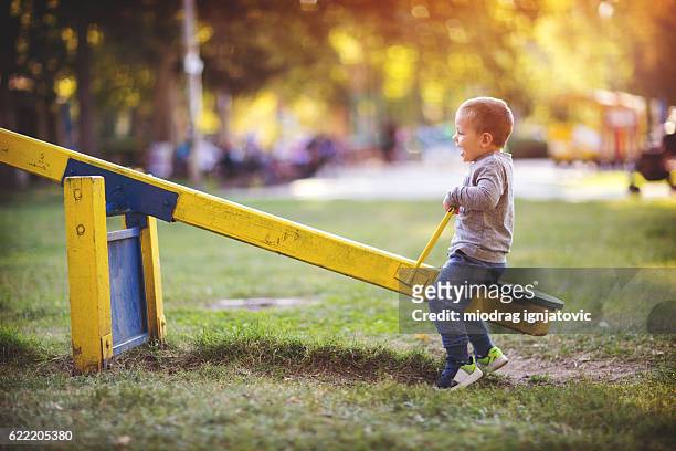 child on the playground - see saw stock pictures, royalty-free photos & images