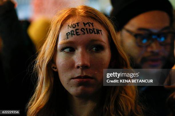 Woman looks on as she takes part in a protest against President-elect Donald Trump in front of Trump Tower in New York on November 10, 2016. / AFP /...