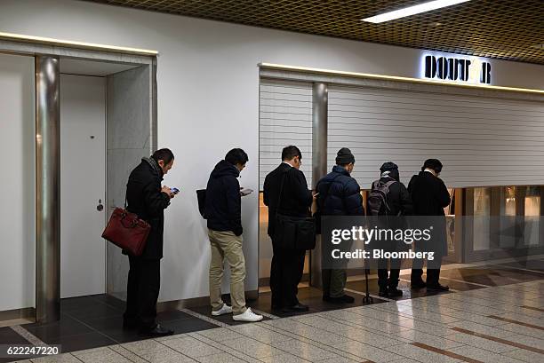 People wait in line outside a store operated by Doutor Coffee Co. Before it opens in Kawasaki, Kanagawa Prefecture, Japan, on Thursday, Nov. 10,...